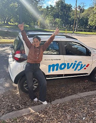 Alumna celebrando junto al auto de Movify